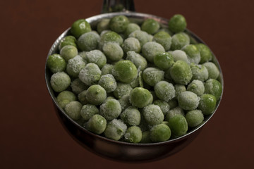 Frozen peas in a metal scoop