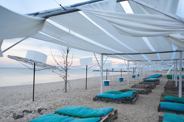 Beach canopies with sun loungers by the sea