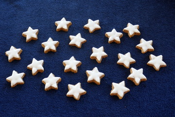 Starry sky. Many home-baked cinnamon stars isolated in front of dark blue Background.