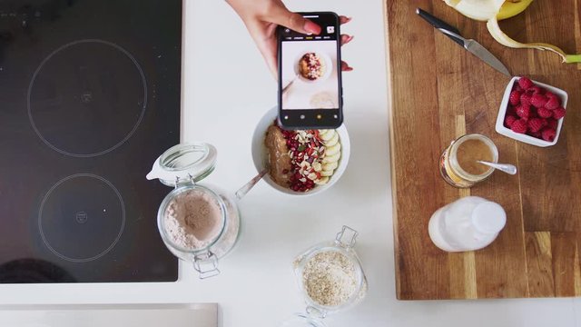 Overhead Shot Of Woman Taking Picture Of Healthy Breakfast On Mobile Phone At Home After Exercise