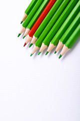 Many different colored pencils on a white background with a place for text and cory space .