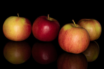 Group of four whole arranged red apple jonagold isolated on black glass