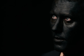 Makeup portrait of a young man with black face, close-up