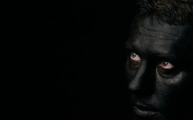Makeup portrait of a young man with black face, close-up