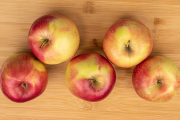 Group of five whole red apple jonagold flatlay on light wood