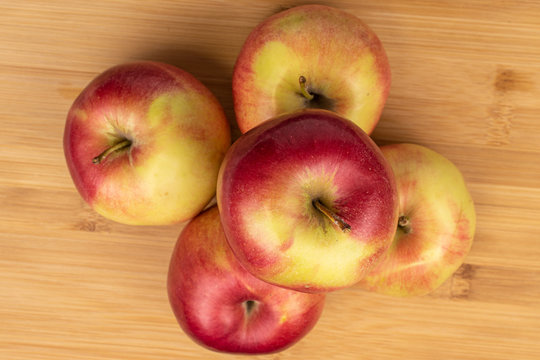 Group of five whole red apple jonagold flatlay on light wood