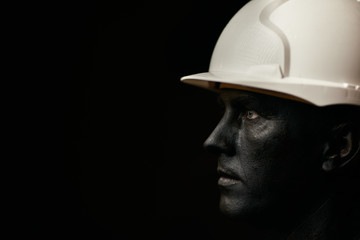 Coal and Oil Miner, dirty worker against dark background, close-up