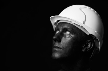 Coal and Oil Miner, dirty worker against dark background, close-up