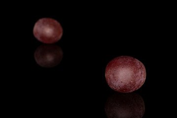 Group of two whole fresh purple grape rose isolated on black glass