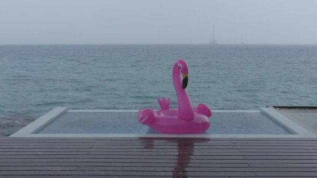 Rain on Vacation - funny video of flamingo float in luxury pool while raining and bad weather on holidays getaway travel.