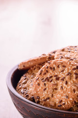 Cookies of sesame seeds, sunflower seeds and other spices on a wooden plate. Bright key