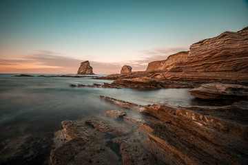 Rocks of Two Sisters of Hendaye with bluish green sunset sky. France