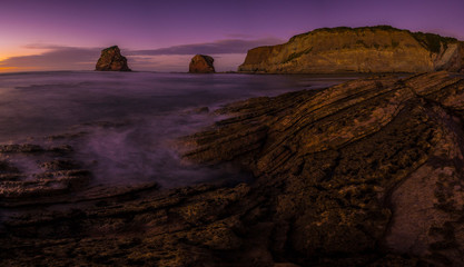 Panoramic of Two Sisters of Hendaye photographed at low tide with a purple sky. France