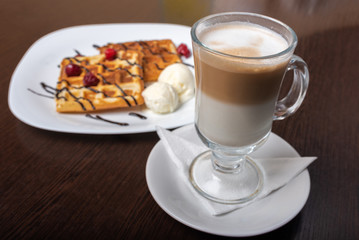 Viennese waffles with latte coffee, on a wooden table.