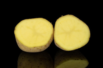 Group of two halves of raw brown potato isolated on black glass