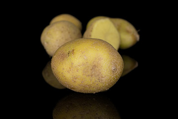 Group of four whole one half of raw brown potato isolated on black glass