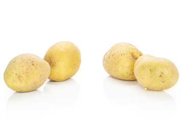 Group of four whole raw brown potato isolated on white background