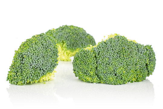 Group of two whole fresh green broccoli front focus isolated on white background