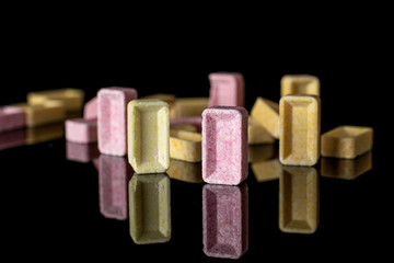 Lot of whole arranged sweet pastel candy isolated on black glass