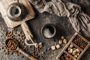 Coffee on wooden board with coffee beans on dark textured background. Top view with copy space. Background with free text space.