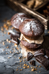 Sweet muffins with on dark textured background.