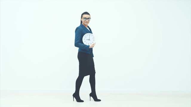 Portrait of beautiful young business woman holding in hands clock, isolated on white background, discipline and punctual concept.