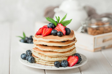 Classic american pancakes with fresh berry on white wood background. Summer homemade breakfast. - obrazy, fototapety, plakaty