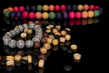 Lot of whole wooden bead fron focus isolated on black glass