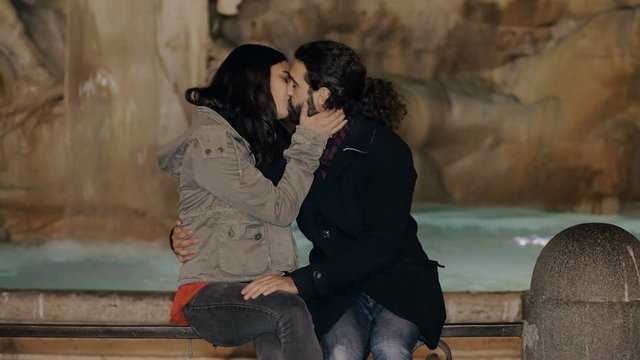 Romatic young lovers kissing,flirting in Piazza Navona. Fountain in background