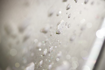 Raindrops on a black car. Abstract rain drops. 