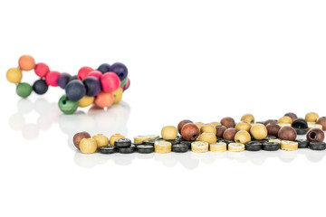 Lot of whole colorful wooden bead in row isolated on white wood