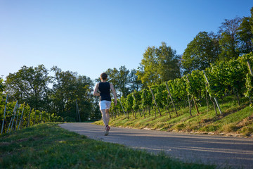 Fototapeta na wymiar back young runner in nature blue sky