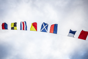 The flags of all canadian province is waving in the wind on the boat in nova scotia 