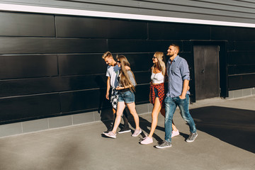 Group of stylish friends, girls and guys walk together on in the city
