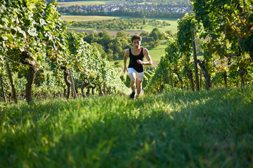 Dynamic jogger running uphill in beautiful nature