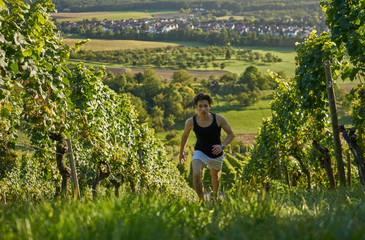 Dynamic jogger running uphill in beautiful nature