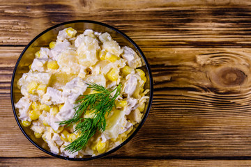 Festive salad with chicken breast, canned pineapple, cheese, sweet corn and mayonnaise on wooden table. Top view