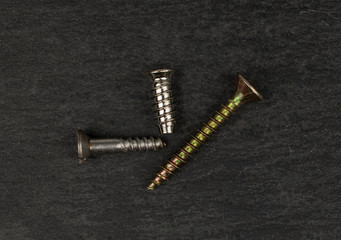 Group of three whole metallic glossy bolt flatlay on grey stone