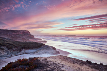 Atardecer en la playa con olas y nubes