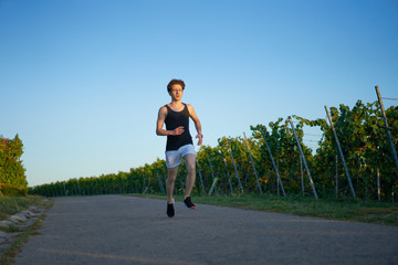 young runner in shorts blue sky