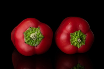 Group of two whole fresh pepper arranged isolated on black glass