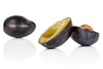 Group of one whole two halves of fresh purple plum isolated on white background