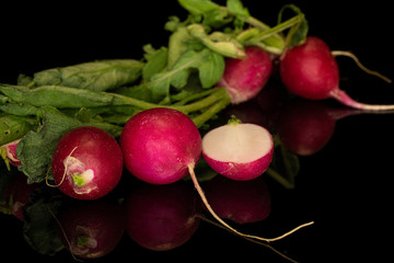 Group of four whole one half of fresh red radish isolated on black glass