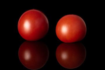 Group of two whole fresh red tomato isolated on black glass