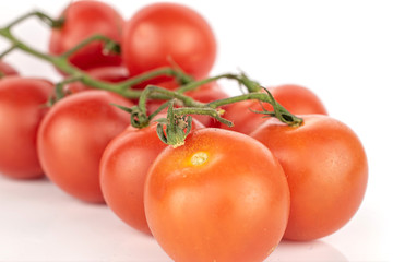 Lot of whole fresh red tomato cluster isolated on white background