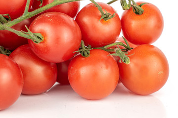 Lot of whole fresh red tomato cluster isolated on white background