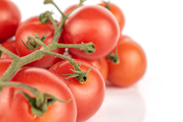 Lot of whole light fresh red tomato cluster isolated on white background