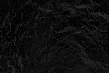 Old crumpled texture black cardboard sheet of empty paper black background.