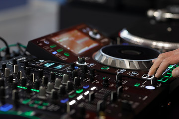 Fototapeta na wymiar DJ using a sound mixer controller to play music