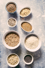 Variaty of raw cereals  on  bowls, top view flat lay,lentils, bulgur and quinoa, hemp seed,sunflower seeds ,brown rice, rice, healthy food concept , clean eating and detox concept.